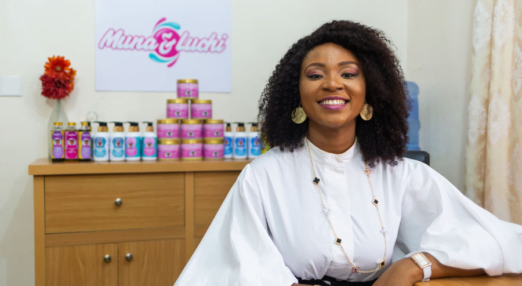 Oluchi founder of Muna & Luchi in Nigeria poses with her hair and body products