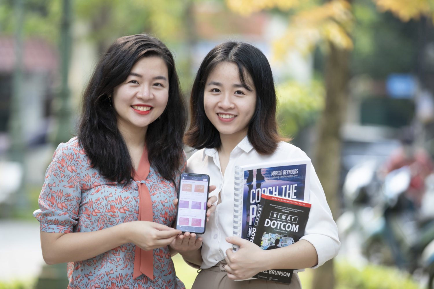 Quynh Nguyen, founder of AZCare, and WEAVE alumna poses with the HerVenture app and a colleague