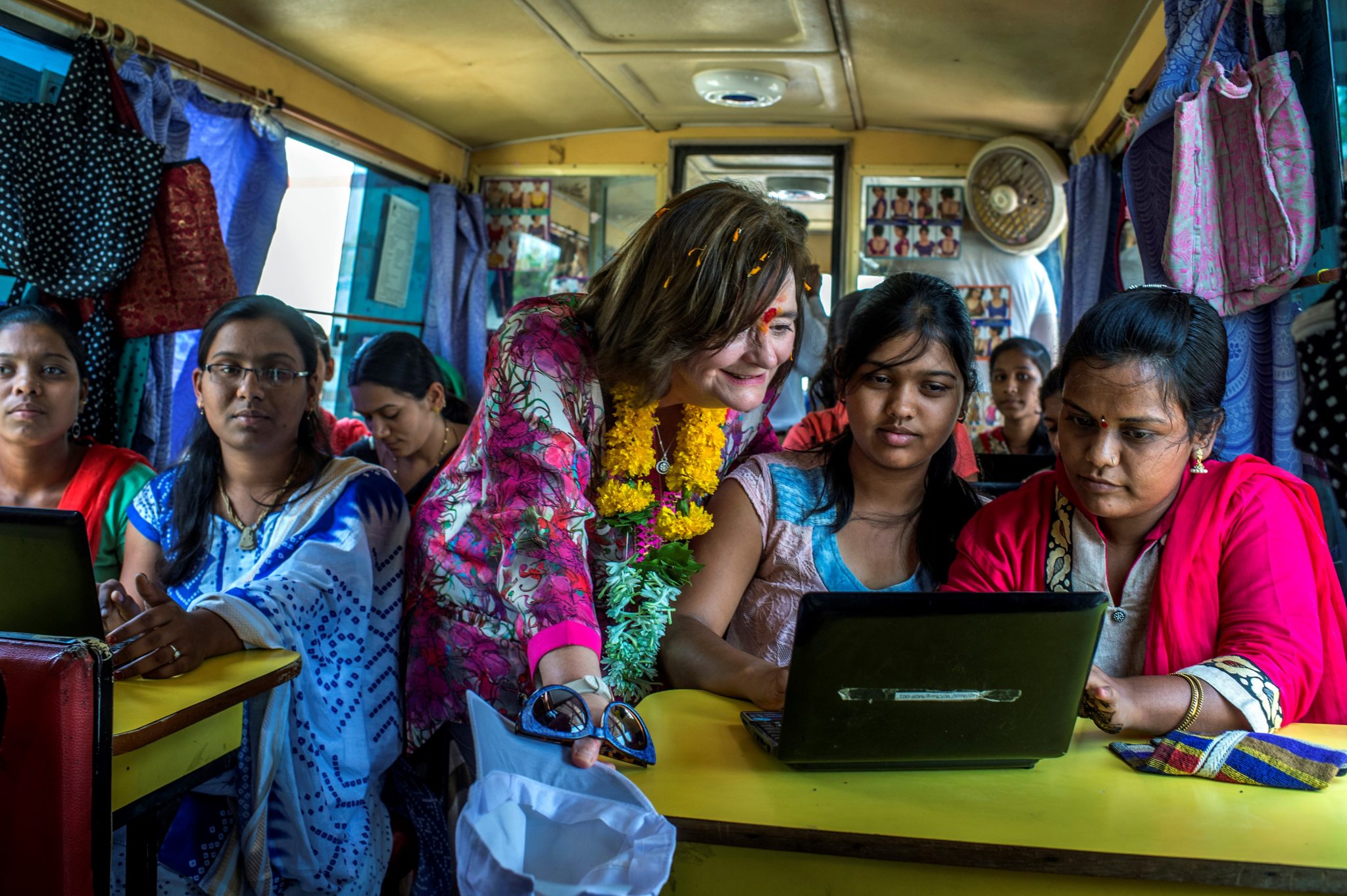 Cherie Blair looks over the shoulder of a girl to see something on her computer