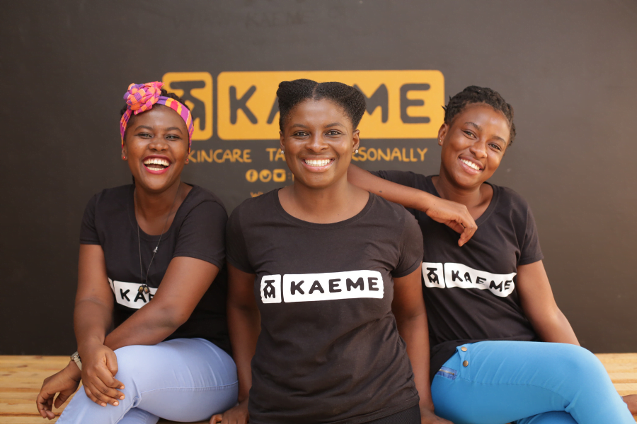 Freda, an entrepreneur and mentee from Ghana poses with staff at her business, Kaeme