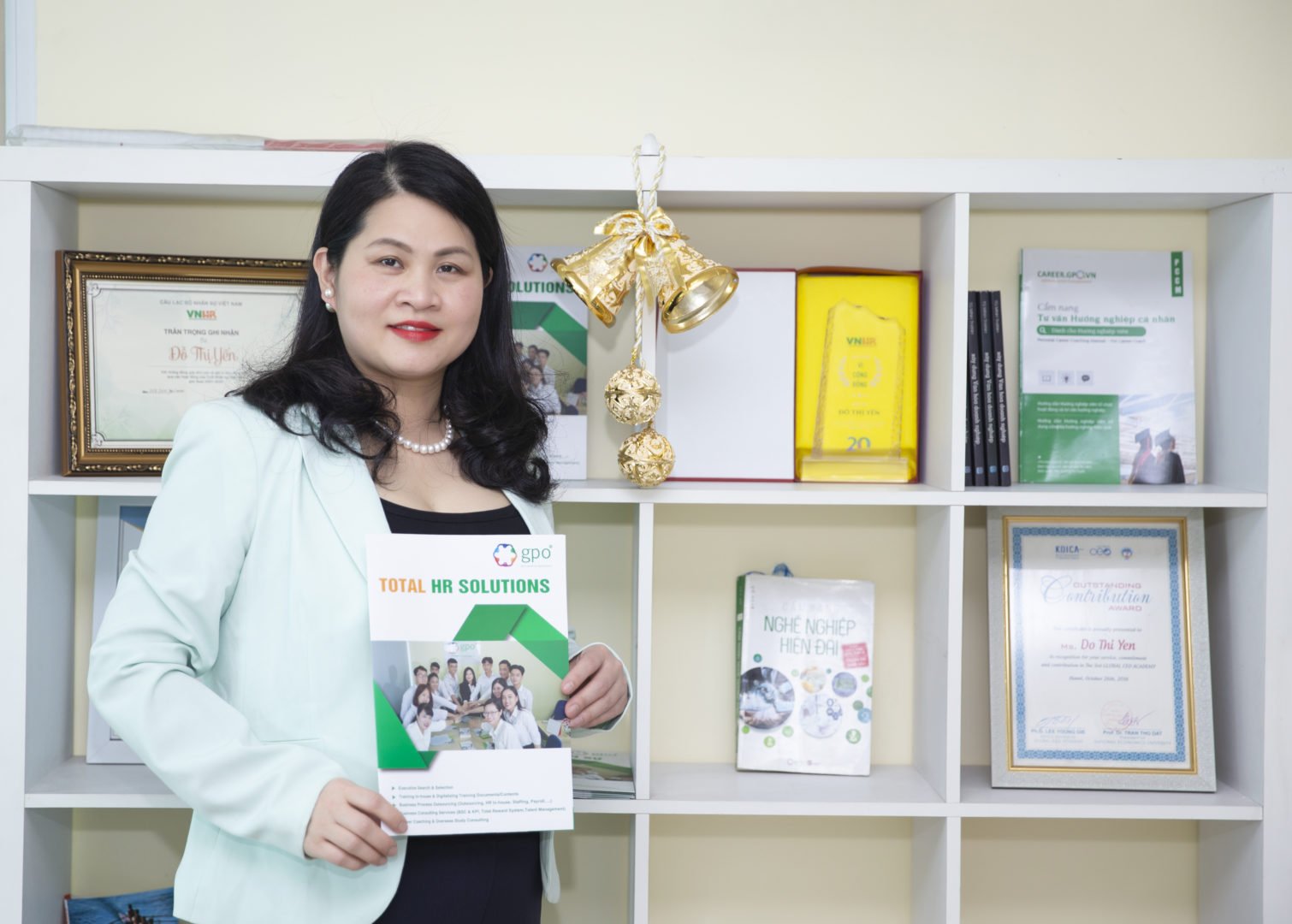 Yen Do WEAVE alumna and woman entrepreneur from Vietnam poses with a brochure for her company, GPO