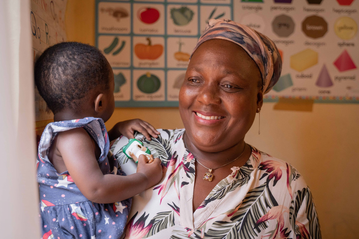 Jenifer Moyo, founder of the Tree of Life crèche, and HerVenture user holds a child at her creche