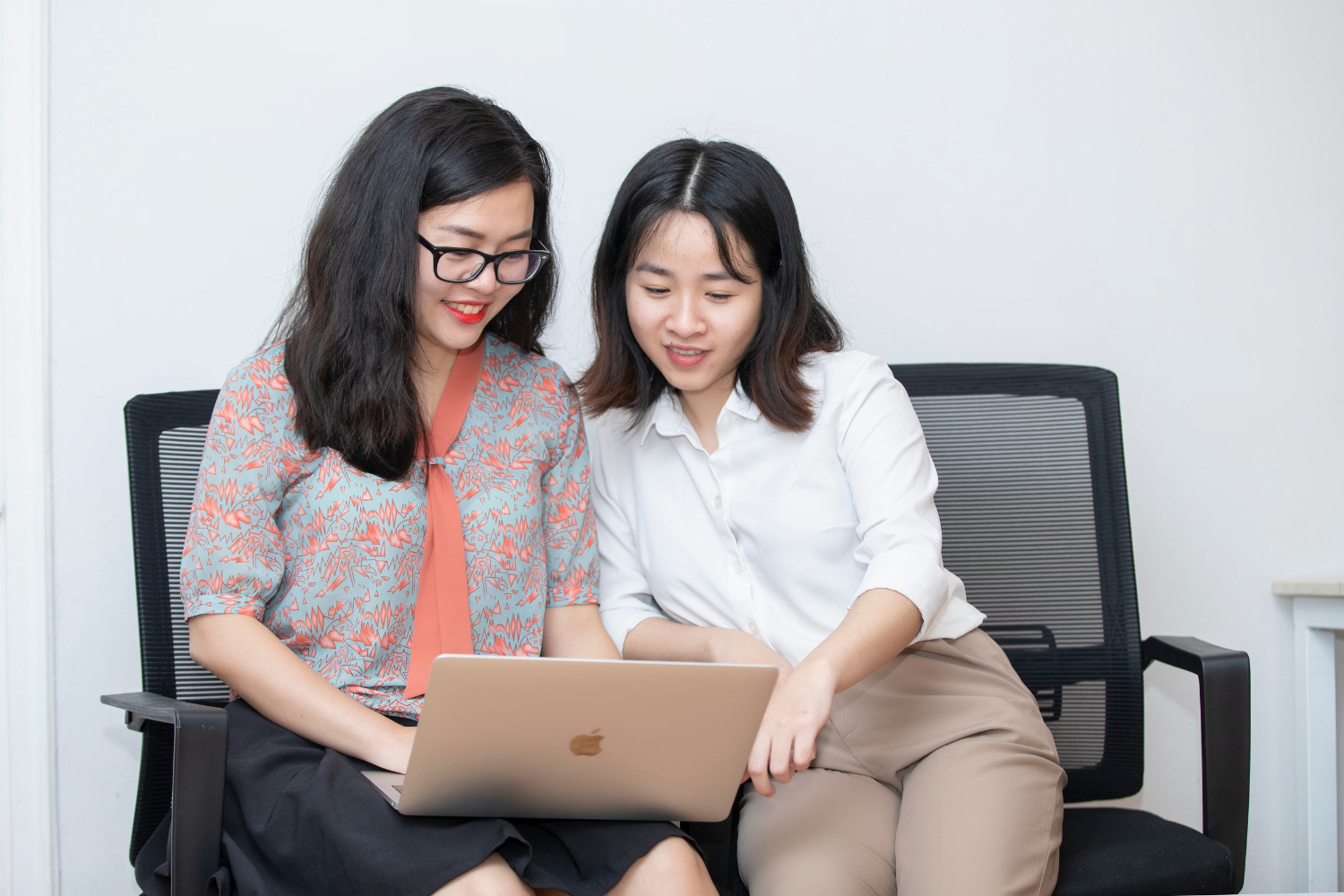 Quynh Nguyen, founder of AZCare, and WEAVE alumna works on the computer with a colleague