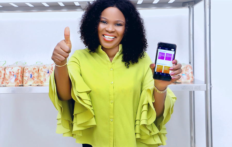 A woman entrepreneur gives a thumbs up while holding up the HerVenture app