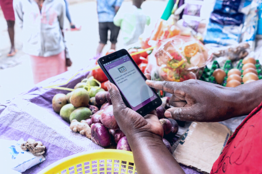A woman entrepreneurs uses the HerVenture app at her market shop