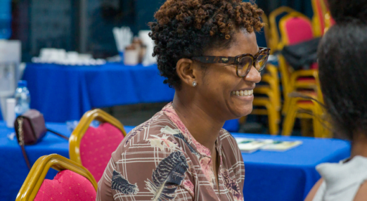 Woman entrepreneur smiles during a Road to Growth session in Guyana