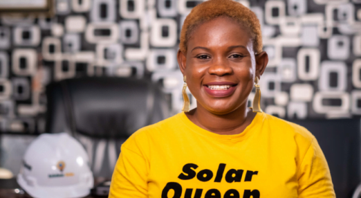 Damilola Asaleye smiles in a solar queen t-shirt at the Ashdam Solar Company office