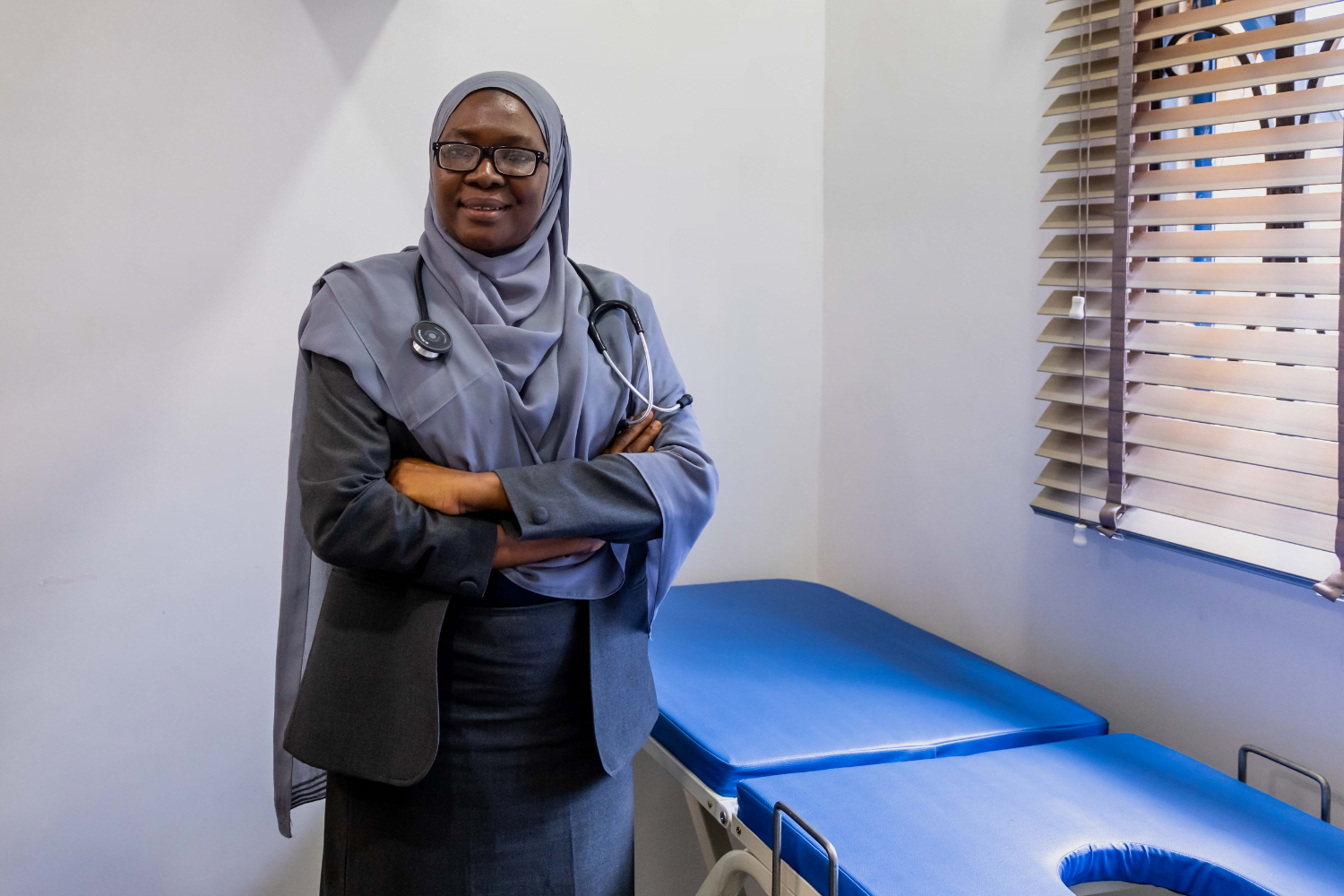 Dr. Hajara Yusuf poses in front of a patient bed at her hospital