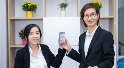 Mai Thi Le Quyen and a staff member at her law firm pose with the HerVenture app