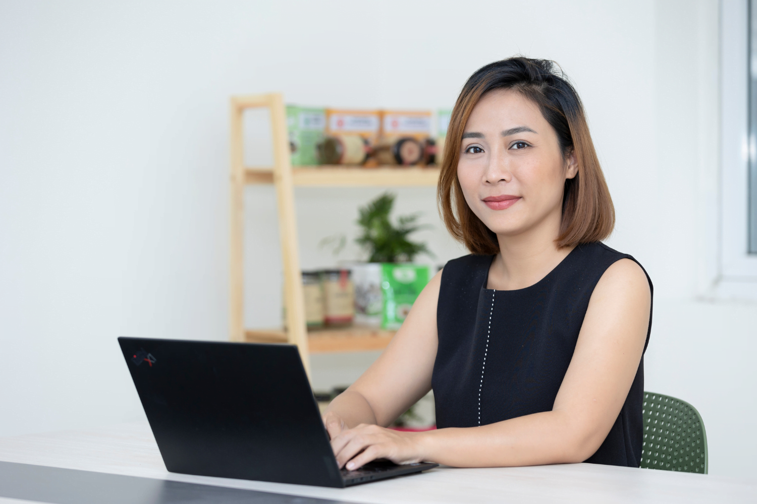 Van Pham does computer work at her business in Vietnam