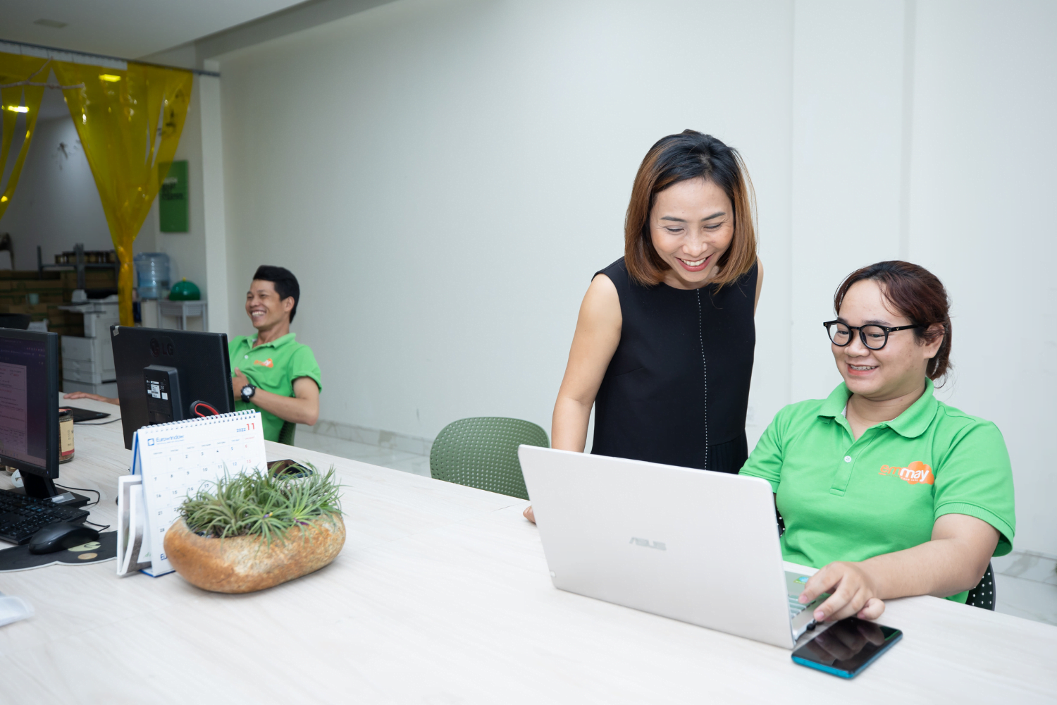 Van Pham does computer work with staff at Emmay Smiling Mushroom in Vietnam