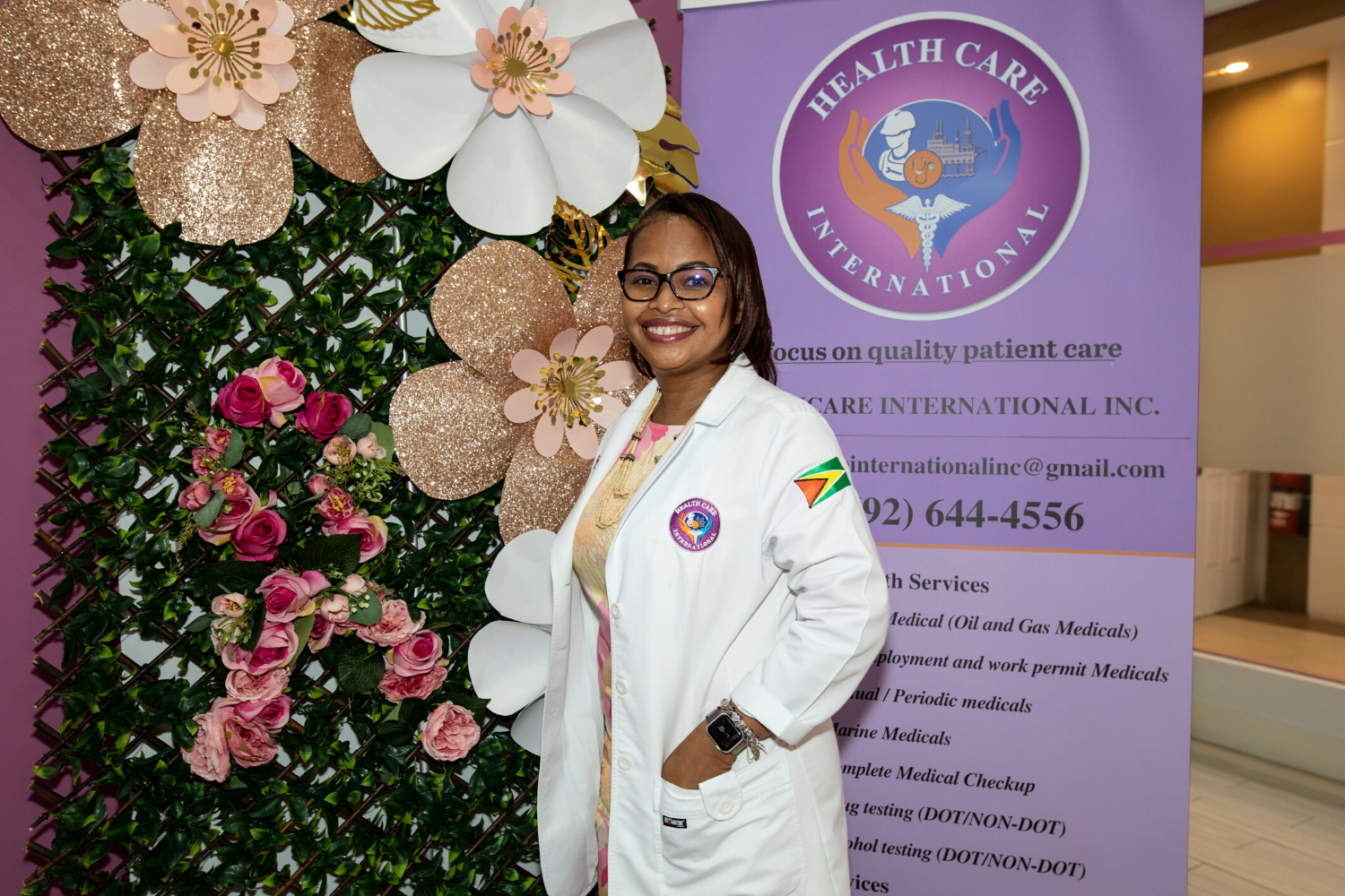 Dr. Ayesha Wilburg poses with the sign at her clinic in Guyana