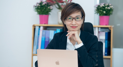 Mai Thi Le Quyen smiles at her desk