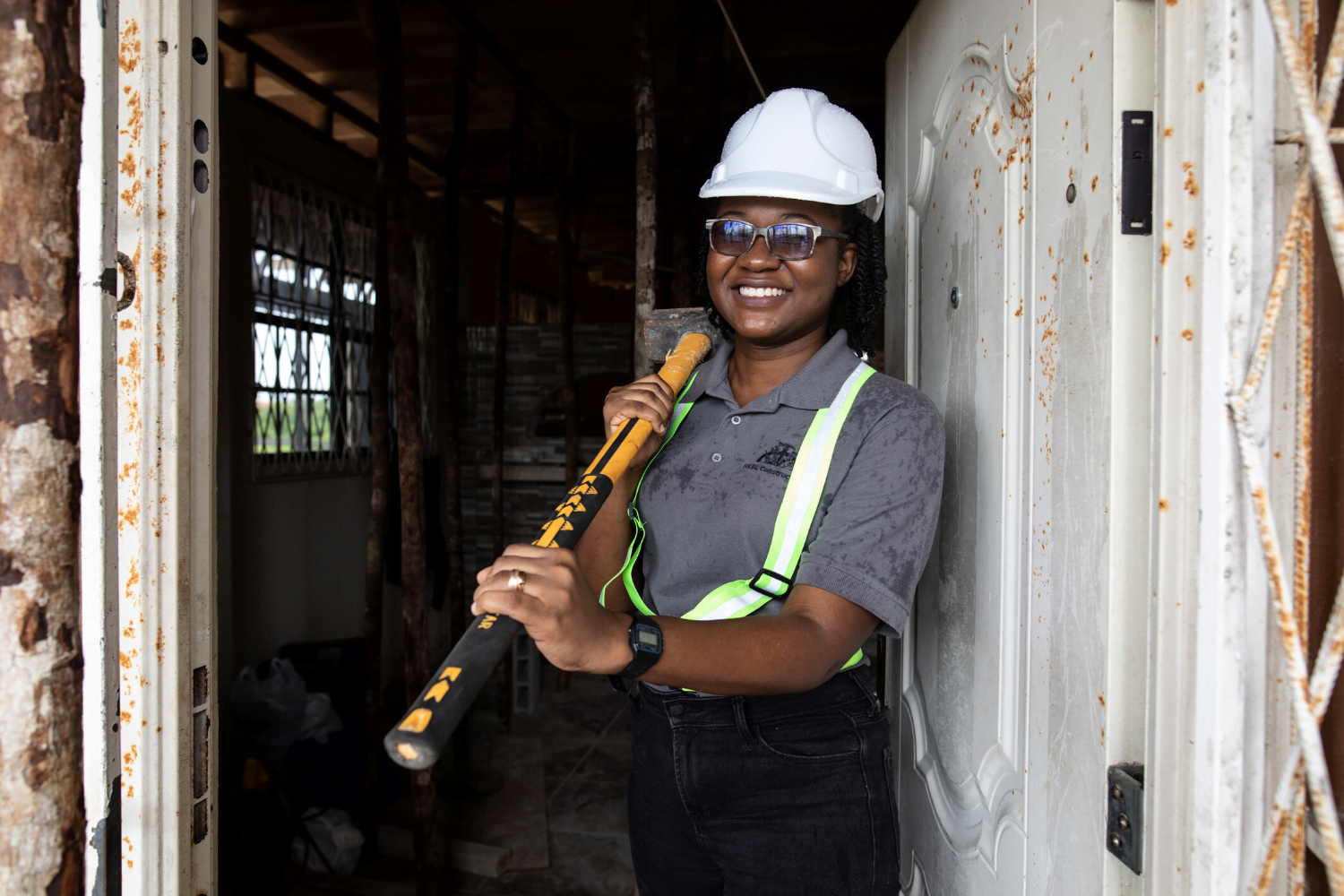 Nakaida Belle-Lindie poses with a hammer at her construction site
