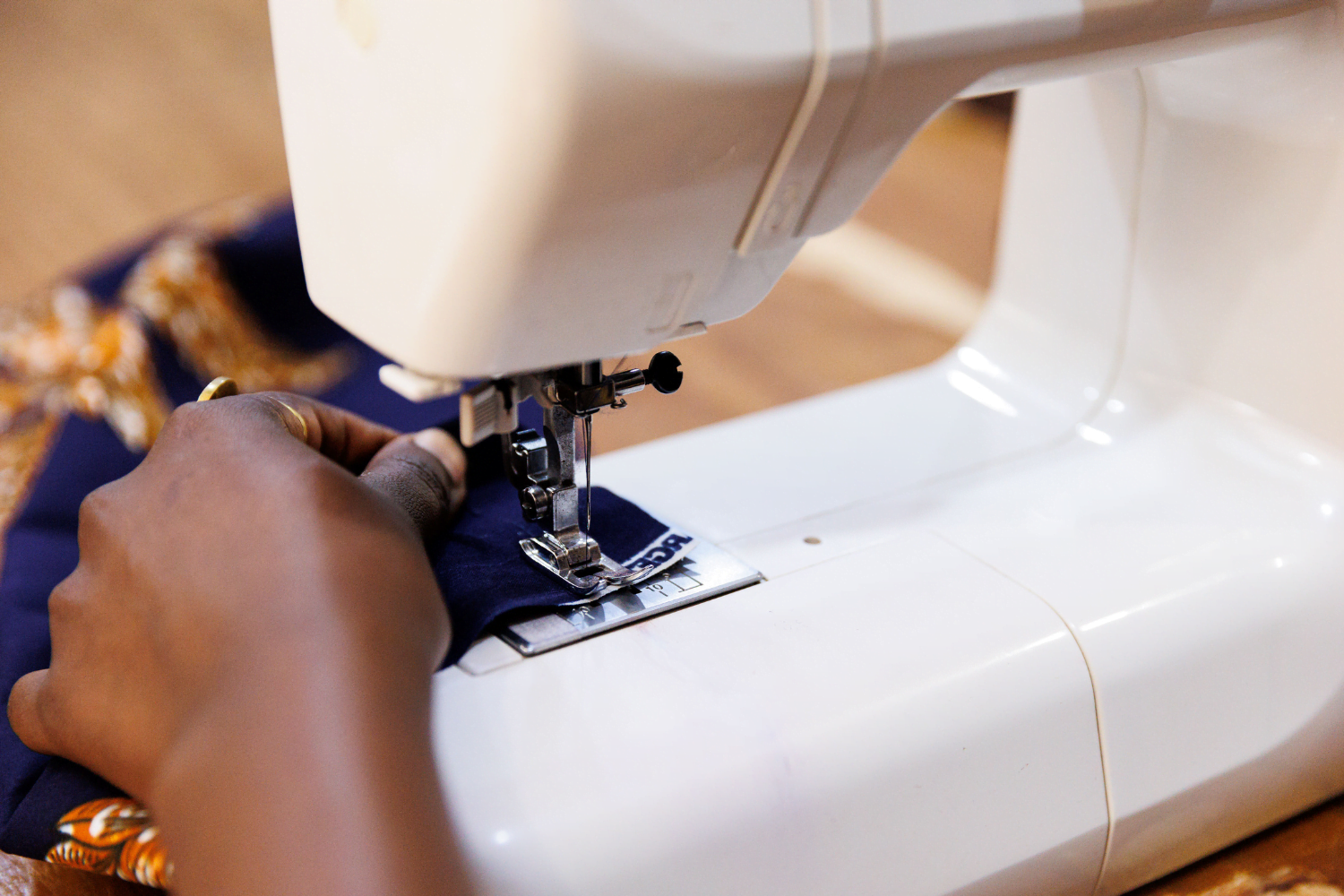 Suubi Njuki's hands using a sewing machine