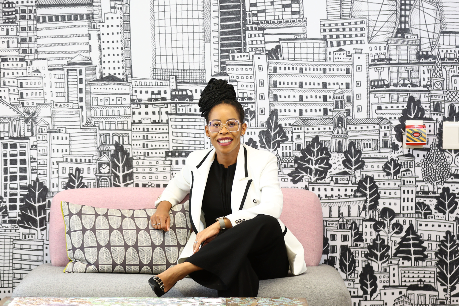 Queen Mokulubete, Founder of Somila Engineering, poses on a sofa in her office.