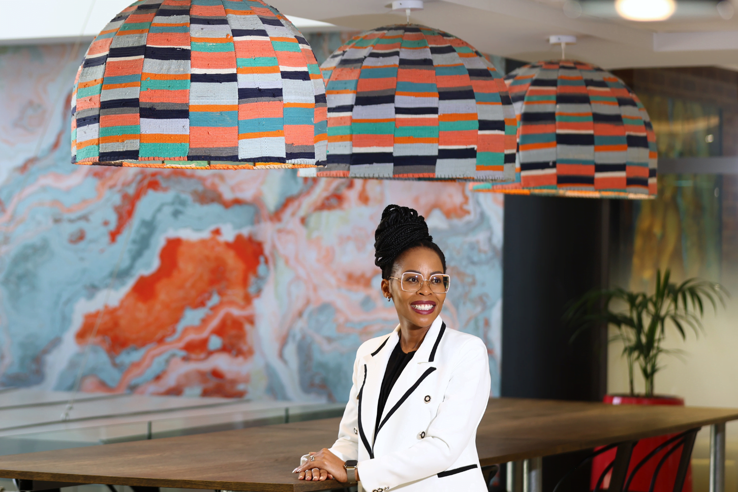 Queen Mokulubete, Founder of Somila Engineering, poses at a boardroom table in her office.