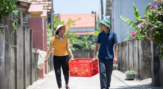 Nguyen Thi Tham, a woman entrepreneur in Vietnam, and her husband carry a basket together