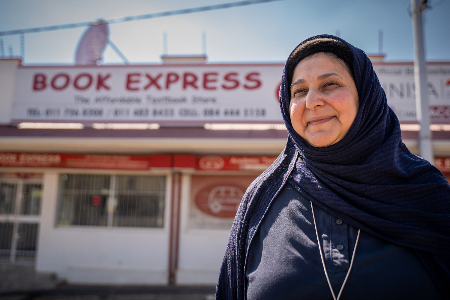 Shereen Cassim Hassim, a female entrepreneur, poses for a photograph in front of her business.