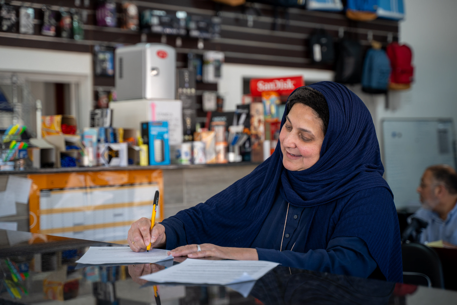 Shereen Cassim Hassim, a female entrepreneur, fills out a form at the reception area of her business.