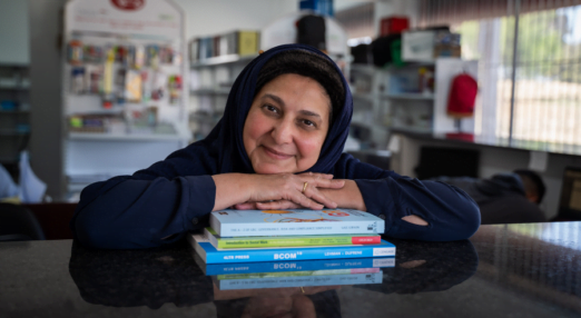 Shereen Cassim Hassim, a female entrepreneur, rests her head on some books.