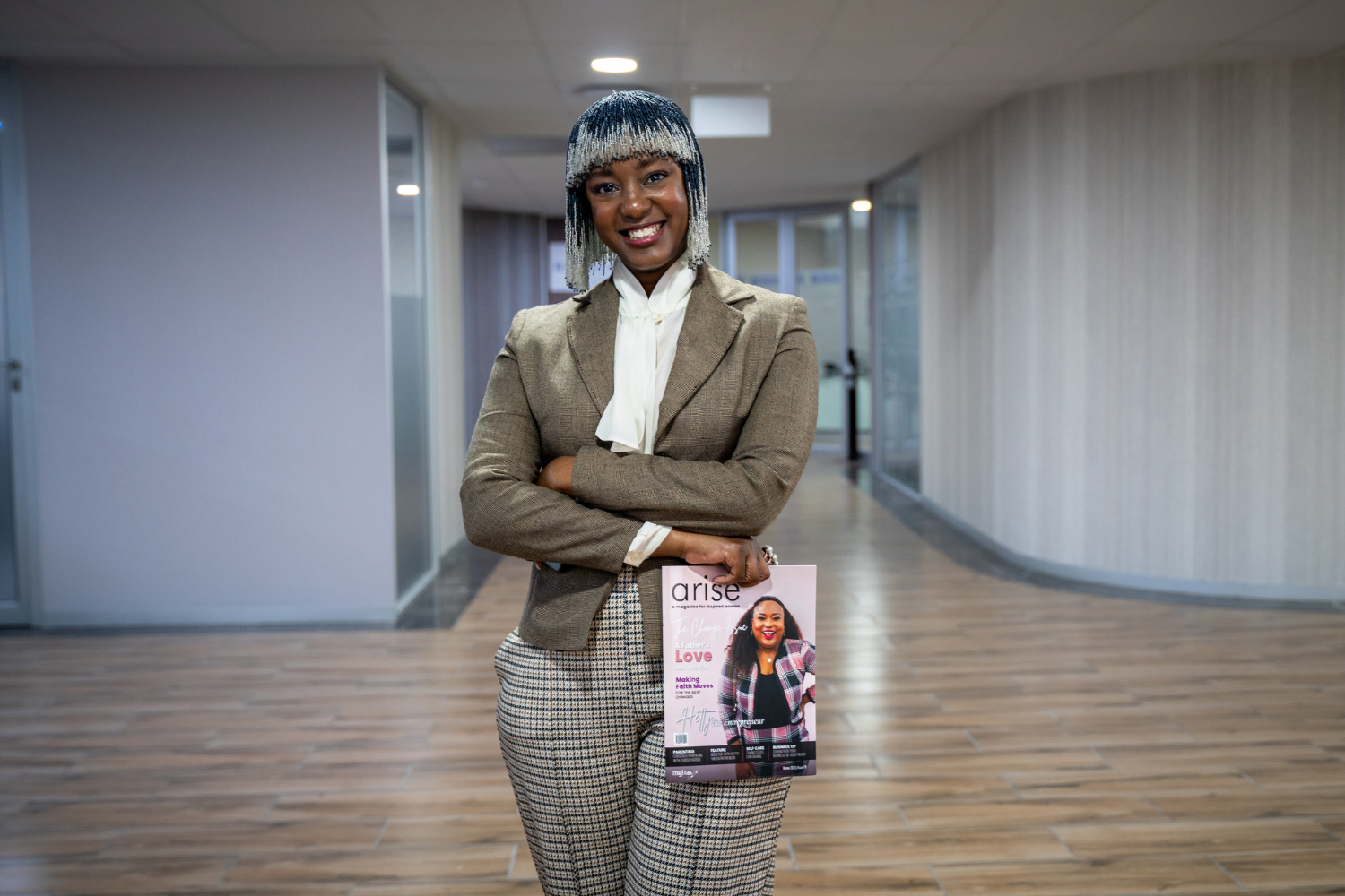 Kea Modise-Moloto, Founder of Arise in Johannesburg, South Africa poses with her magazine in the hallway of her business.