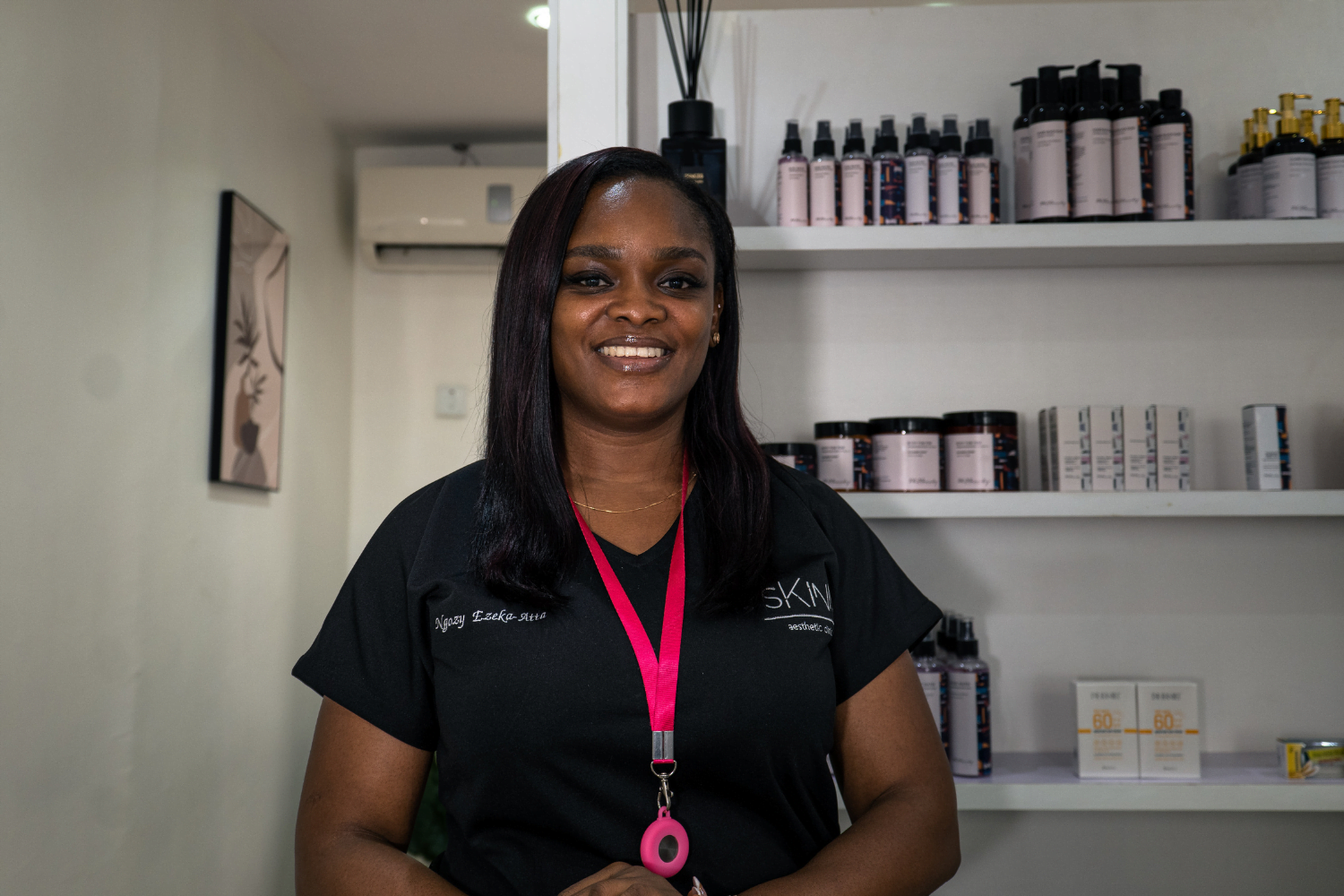 Ngozy Ezeka-Atta, Owner of Jaga Beauty in Lagos, Nigeria smiles in front of beauty products.
