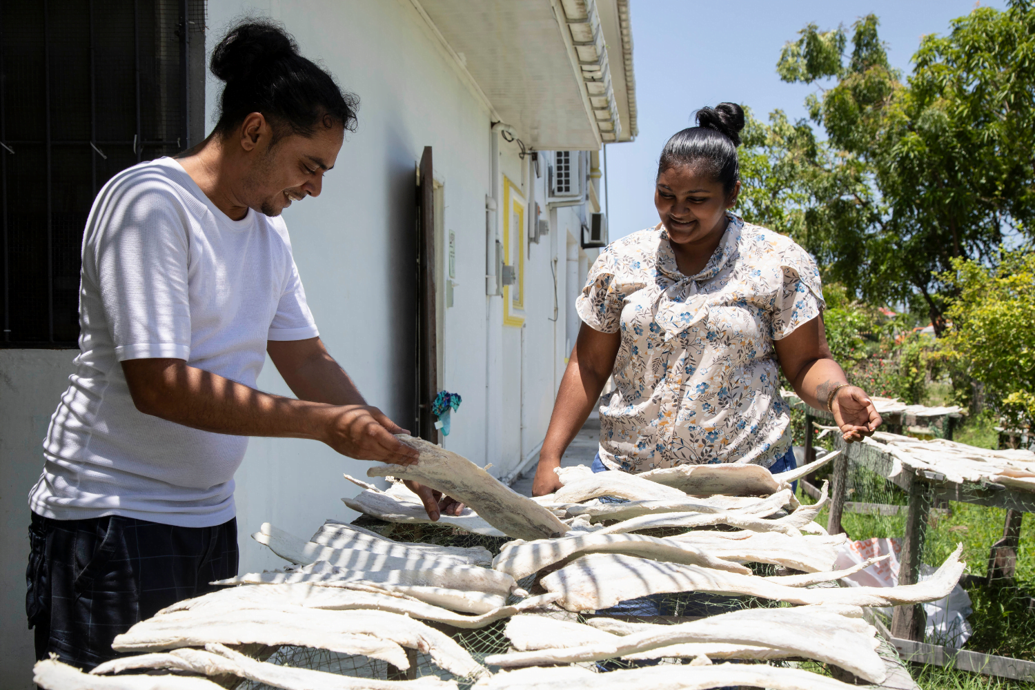 Radhika Basdeo, Sole Proprietress of Basdeo's Dynasty in Guyana instructs a male staff member on drying fish.