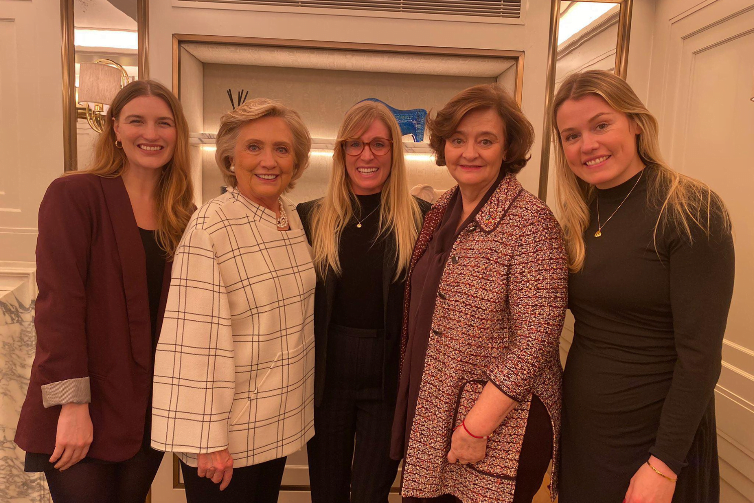 The Cherie Blair Foundation for Women's team stands in a line with Hillary Clinton, Cherie Blair CBE KC, and Anna Stoecklein, host of The Story of Woman podcast.