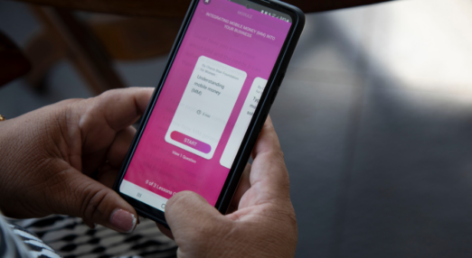 Hands holding a smartphone with the HerVenture app on the screen.